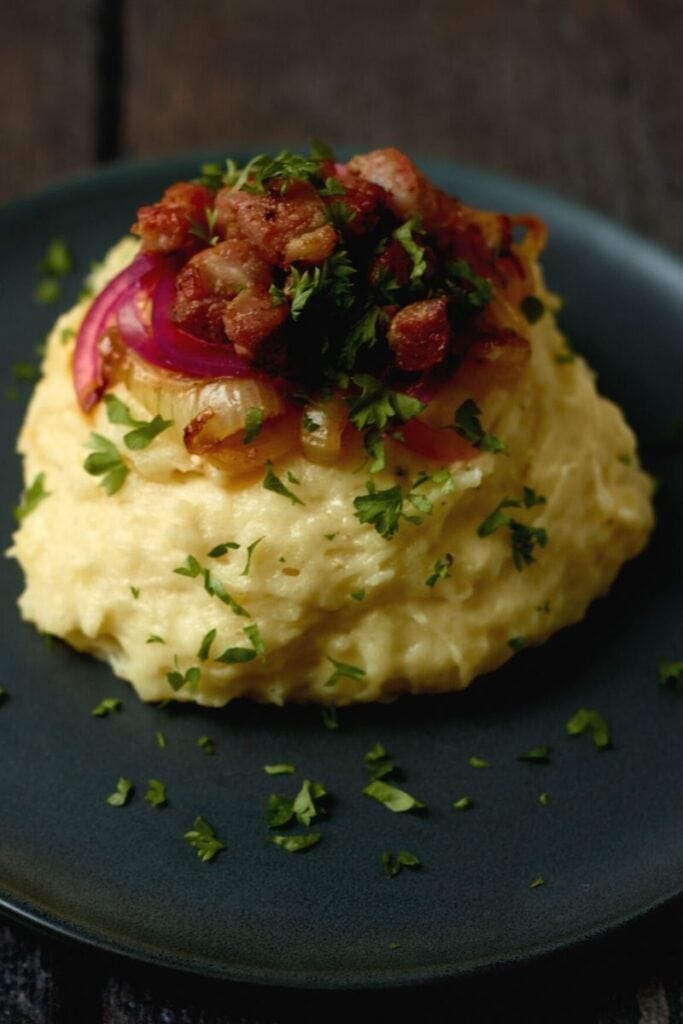 Klassisk brændende kærlighed der både er cremet og luftig. Kartoffelmos med sprøde baconstykker og syltede rødløg